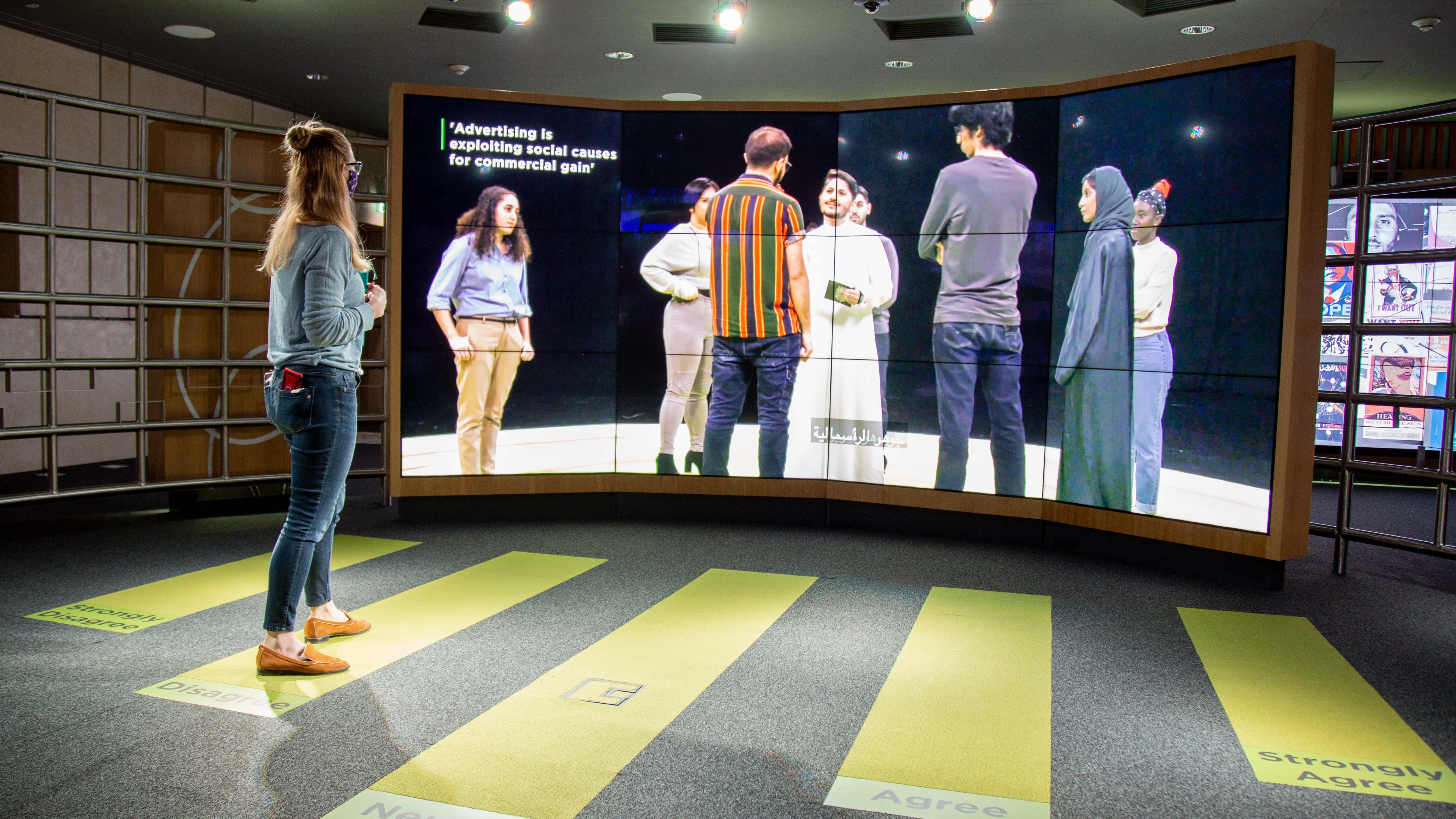 Visitors attending the exhibition examine persuasion in various aspects of everyday life.