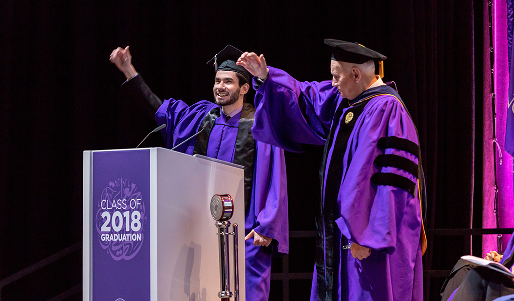 Fouad Hassan, the student speaker at NU-Q’s graduation ceremony, and Dean Everette E. Dennis perform the Northwestern Wildcat cheer.