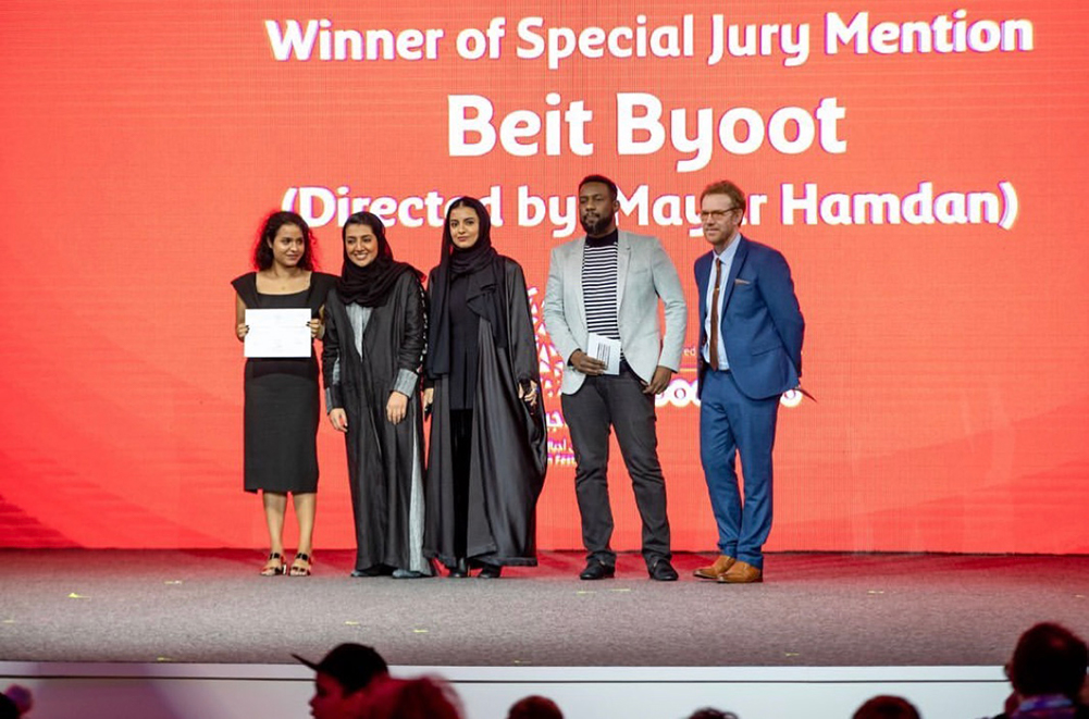 Mayar Hamdan, NU-Q alumna '15 and director of "Beit Byoot" receives the Special Jury Award during Ajyal's closing ceremony. Hamdan (far left) is accompanied by representatives from DFI, Ooredoo Qatar, and filmmaker Amjad Abu Alala. Photo credit: Ooredoo Qatar