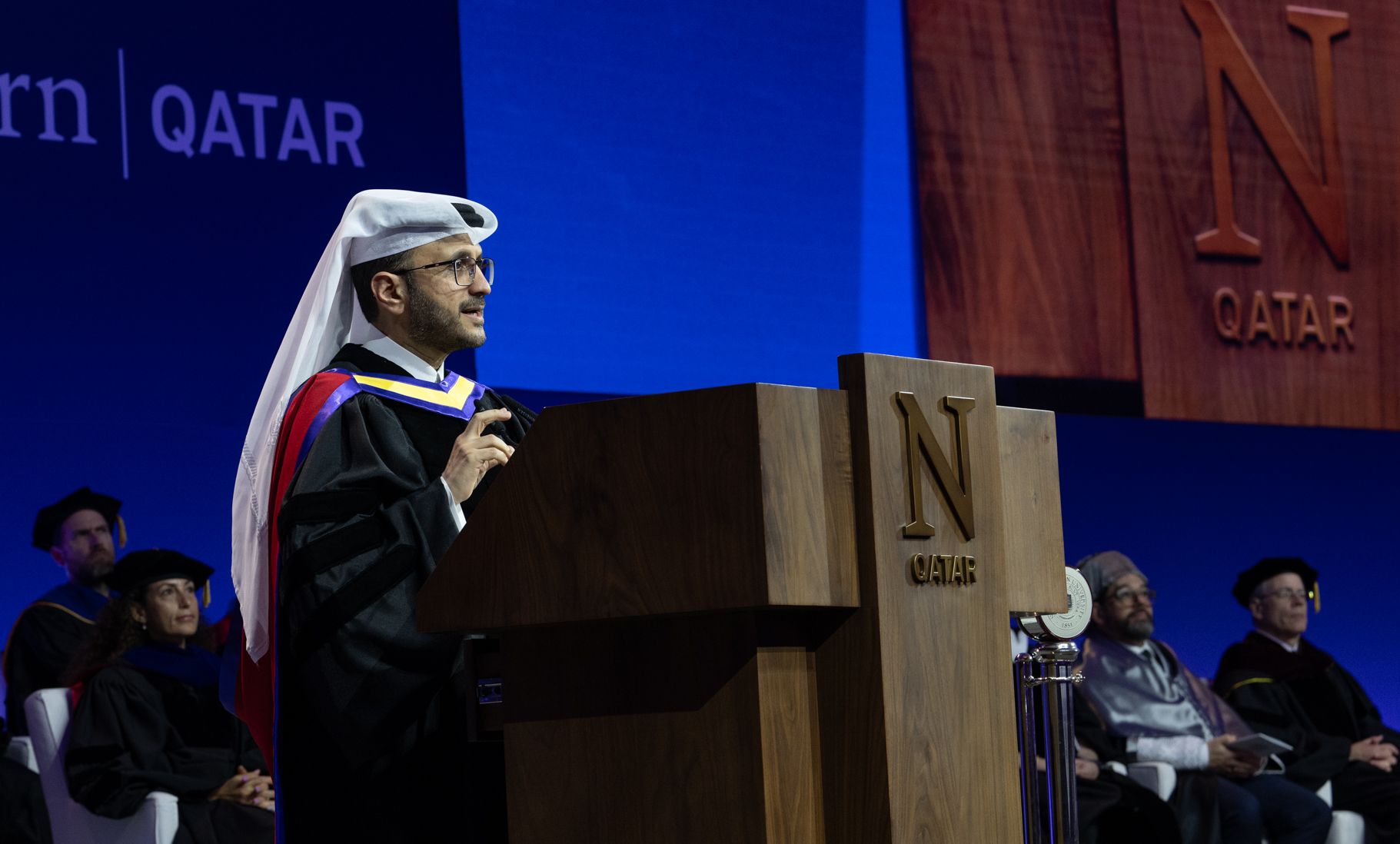 Dr. Majed Mohammed Al-Ansari delivers the graduation address, emphasizing the responsibility of communication and the impact of words in shaping public understanding.